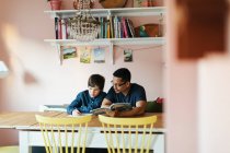 Отец помогает сыну с домашним заданием — стоковое фото