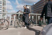Homme avec vélo et téléphone intelligent dans la rue — Photo de stock