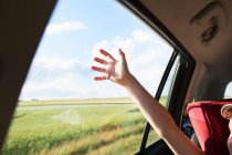 Mädchen mit erhobenem Arm im Auto — Stockfoto