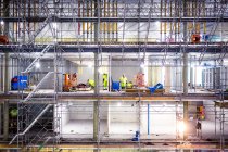 Workers on scaffolding at construction site — Stock Photo