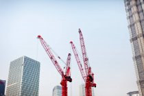 Low angle view of cranes and skyscrapers — Stock Photo