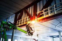 Construction worker welding from crane — Stock Photo