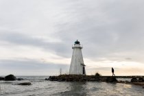 Woman walking by lighthouse at Lake Vattern, Sweden — Foto stock