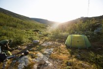Femme camping au coucher du soleil — Photo de stock
