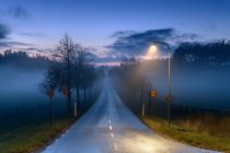 Rua luz por estrada ao pôr-do-sol — Fotografia de Stock