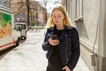 Giovane donna che utilizza lo smart phone a Stoccolma, Svezia — Foto stock
