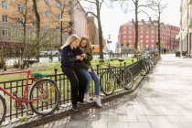 Jovens mulheres usando telefone inteligente no parque em Estocolmo, Suécia — Fotografia de Stock