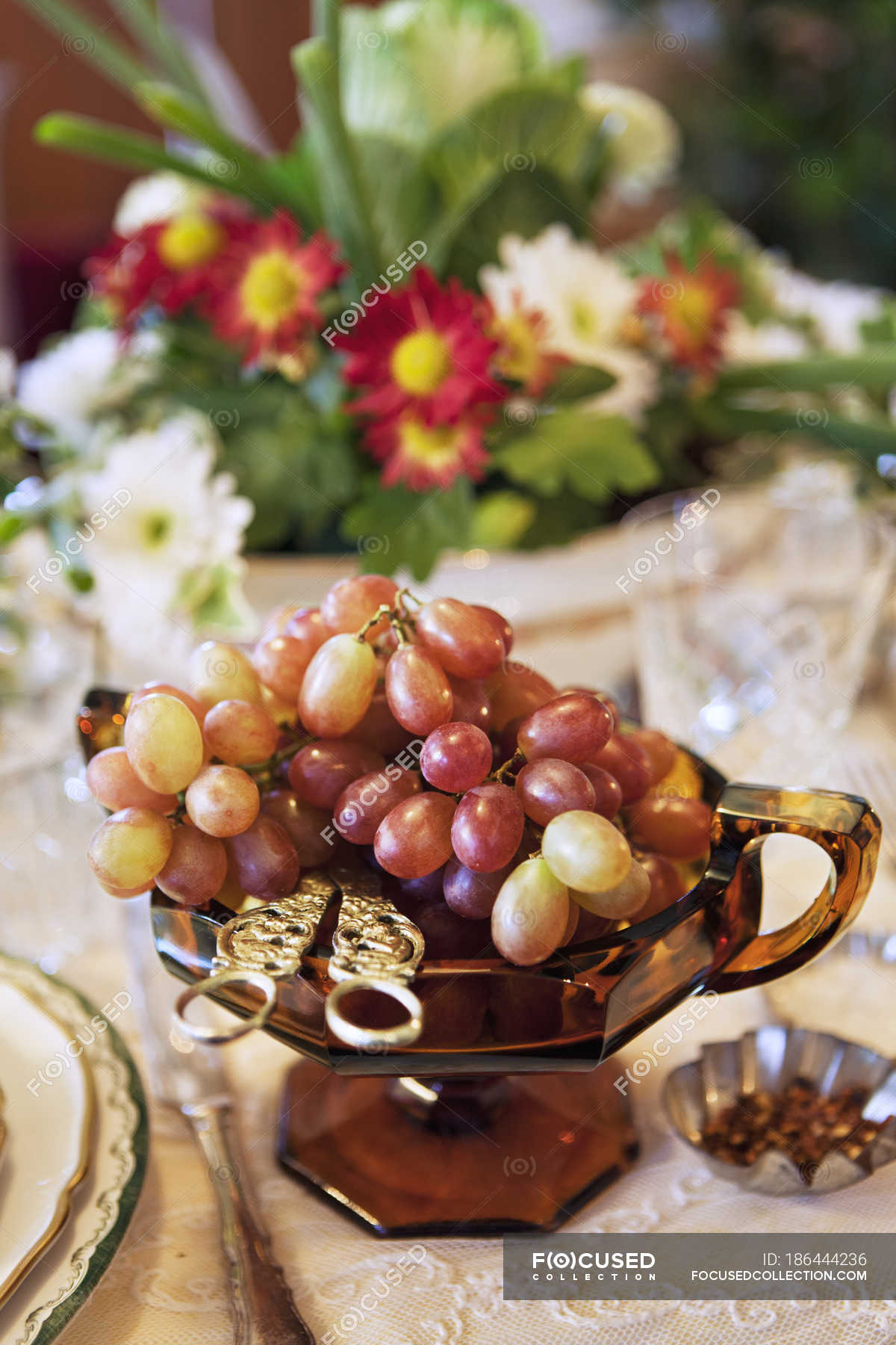 Grapes in glass dish on served table — fruit, indoors Stock Photo