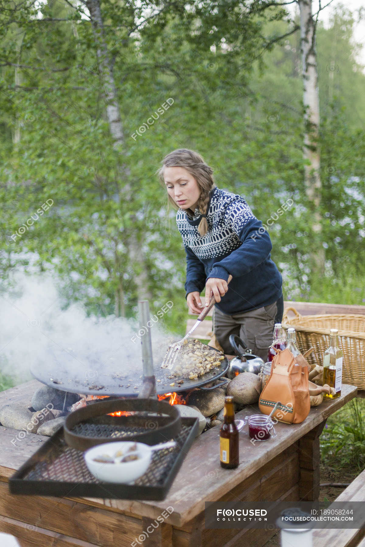 Woman Cooking On Fire Pit At Forest Focus On Foreground Copy