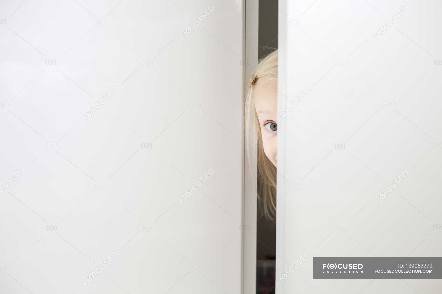 Girl Looking At Camera Through Door Long Hair 6 7 Years Stock
