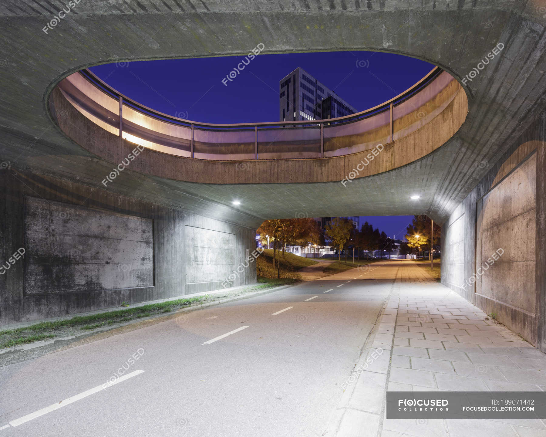 Road under bridge with buildings in background — outdoors, horizontal ...