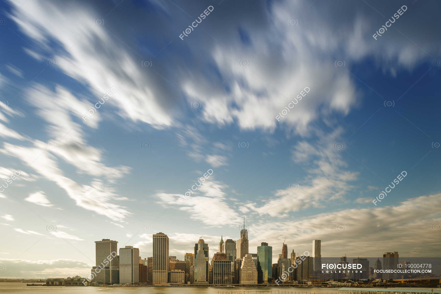 Skyline Of Manhattan Against Sky With Clouds American Buildings Stock Photo