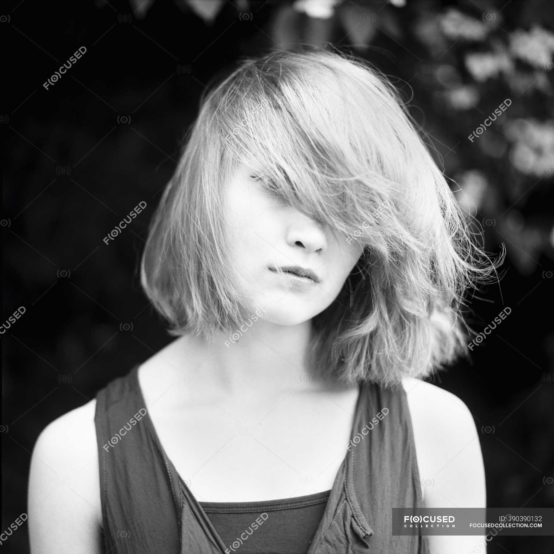 Portrait Of Young Woman Tousling Hair Looking At Camera Young