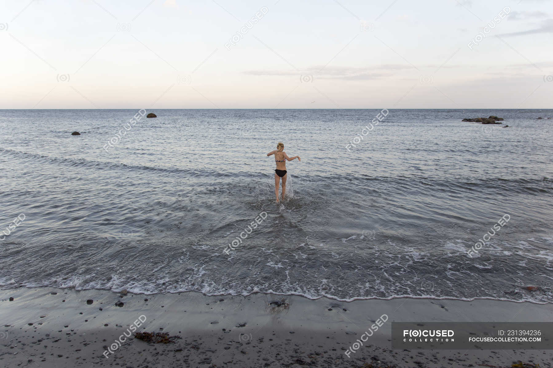 Rear view of girl in bikini wadding in sea in Ornahusen, Sweden — skane ...