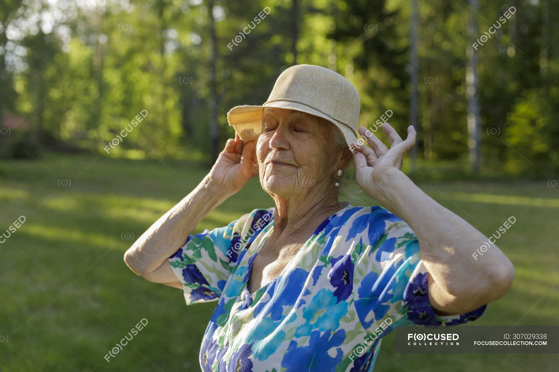 Senior woman wearing sun hat in field — ostergotland, daytime - Stock ...