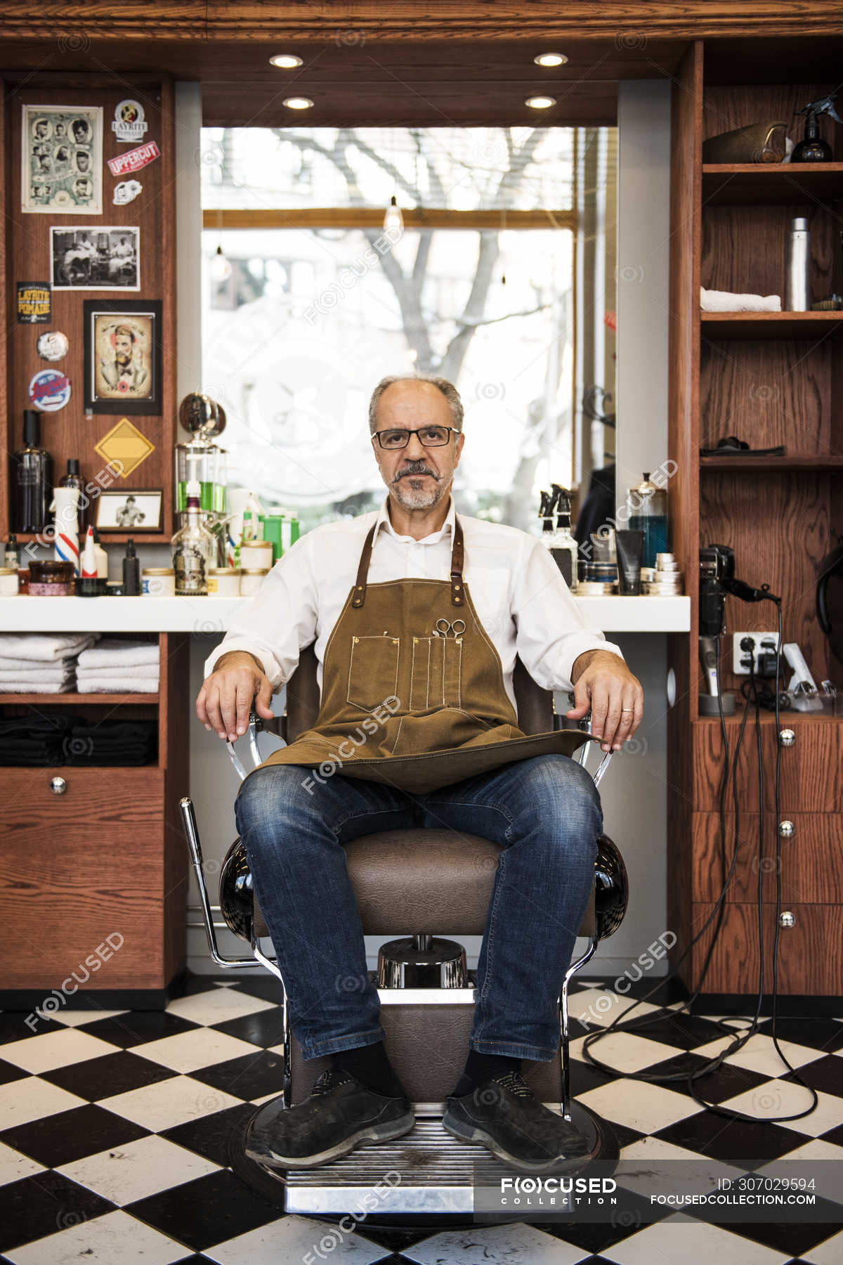 Barber sitting in chair in barbershop, selective focus — beard, Facial ...