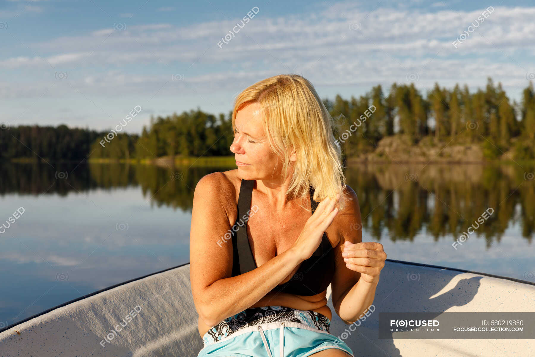 Mature Woman Sitting In Boat On Lake Forest Mature Adult Stock