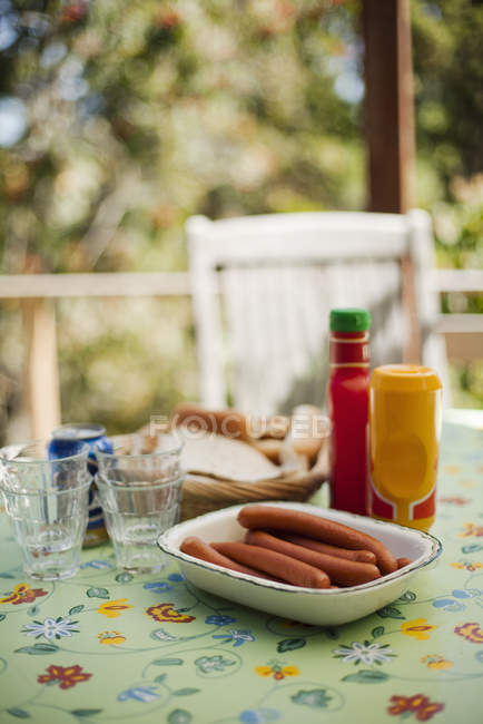 Ingredients for hot dogs on garden table — Stock Photo