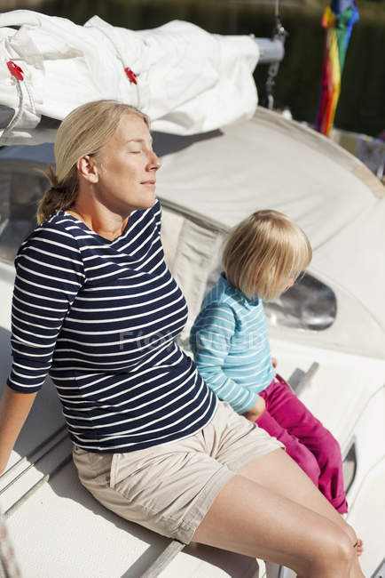 Mother and daughter relaxing on deck of boat — Stock Photo