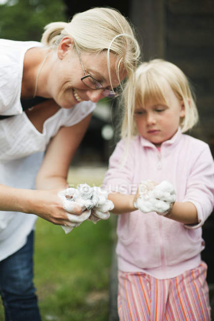 Мати і дочка формують глину, фокус на передньому плані — стокове фото