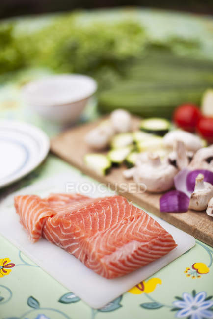 Sliced salmon with vegetable ingredients on table — Stock Photo