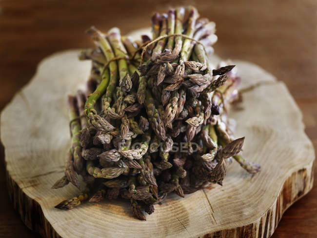 Close-up of organic asparagus on tree stump — Stock Photo
