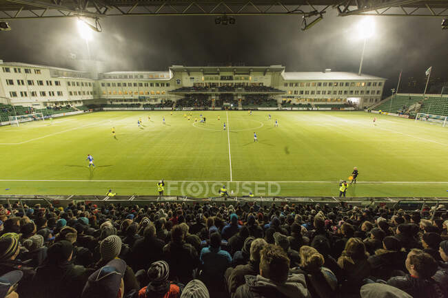 Stadium at night, high angle view with people watching soccer match. Sundsvall, Sweden — Stock Photo
