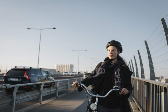 Mujer joven caminando con bicicleta, enfoque selectivo - foto de stock