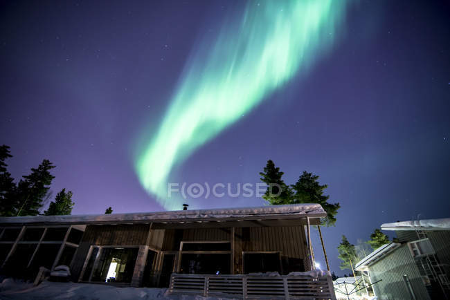 Galpão edifício sob aurora boreal é iluminado céu — Fotografia de Stock