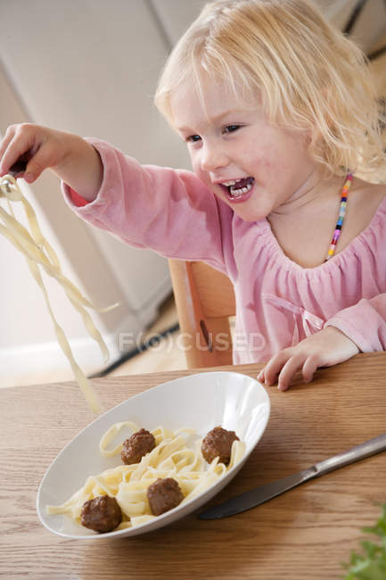 Mädchen isst Spaghetti mit Frikadellen, selektiver Fokus — Stockfoto