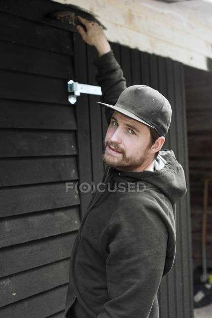 Homem pintando casa e olhando para a câmera — Fotografia de Stock