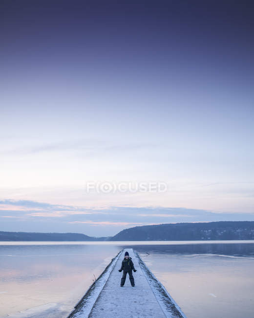 Front view of boy on footbridge looking at camera — Stock Photo