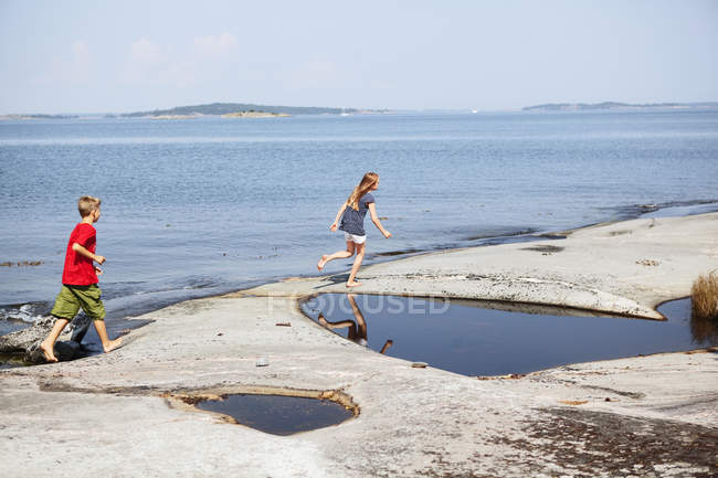 Vista laterale del ragazzo e della ragazza che camminano sulla spiaggia — Foto stock
