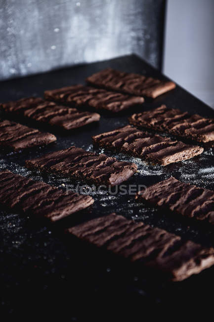 Baked chocolate biscuits on messy table — Stock Photo