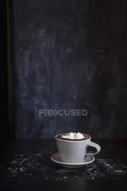 Tazza di cioccolata calda con crema sul tavolo — Foto stock