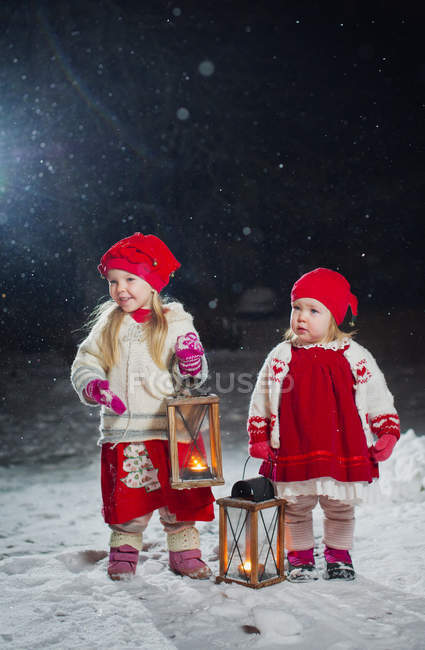 Sisters with lanterns standing in backyard at night — Stock Photo
