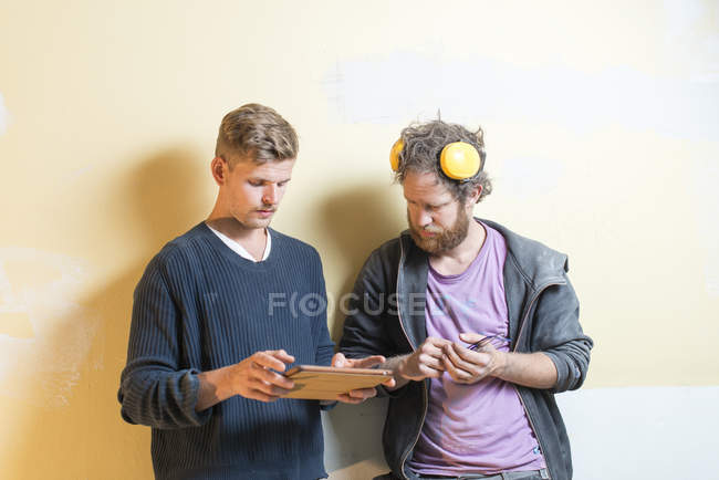 Друзья, использующие цифровой планшет во время ремонта, избирательный фокус — стоковое фото