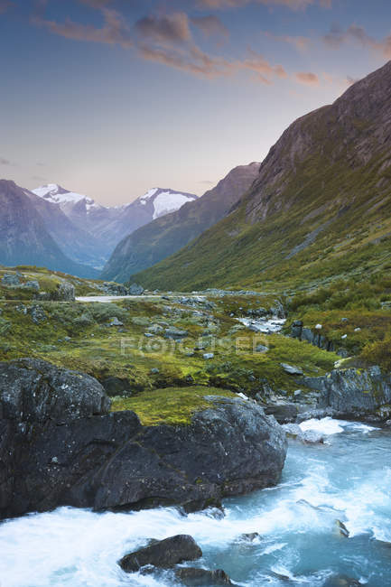 Stream with rocky shores in mountain valley at dusk — Stock Photo
