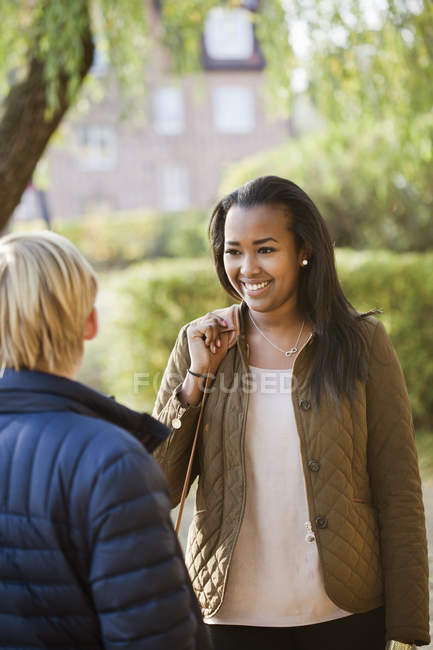 Teenage friends talking in park, differential focus — Stock Photo