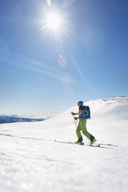Vista laterale dello sciatore nel paesaggio invernale — Foto stock