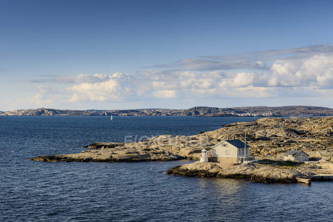 Vista de la costa con casa en la luz del sol brillante - foto de stock