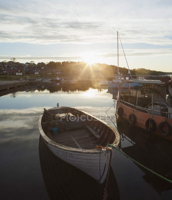 Boats moored in canal with setting sun — Stock Photo