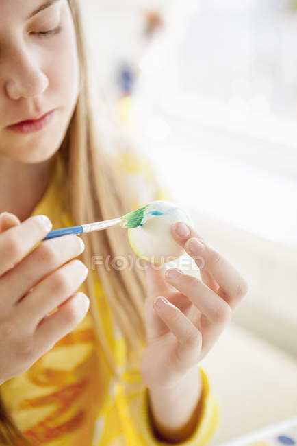 Girl painting egg, differential focus — Stock Photo