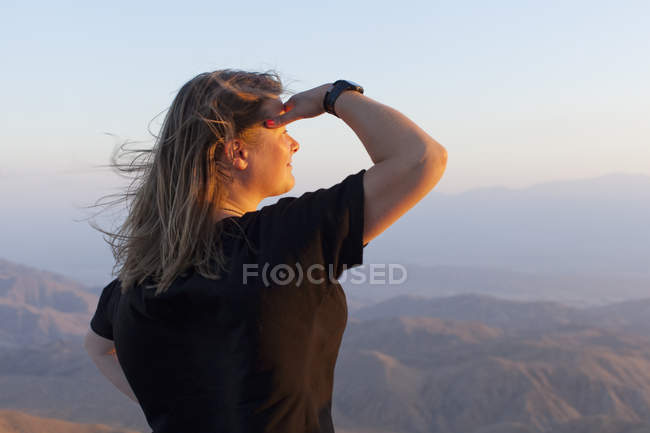 Turista feminino olhando para a vista ao pôr do sol — Fotografia de Stock