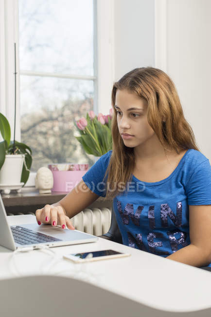 Side view of teenage girl doing homework — Stock Photo
