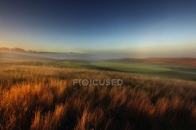 Malerischer Blick auf Felder und Golfplatz bei Sonnenuntergang — Stockfoto