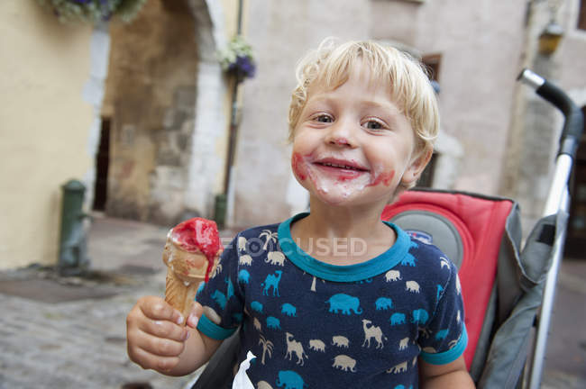 Garçon souriant tenant une crème glacée — Photo de stock