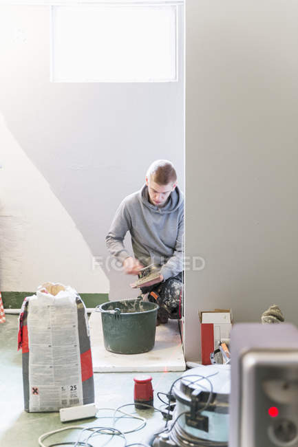 Skilled worker tiling walls, selective focus — Stock Photo