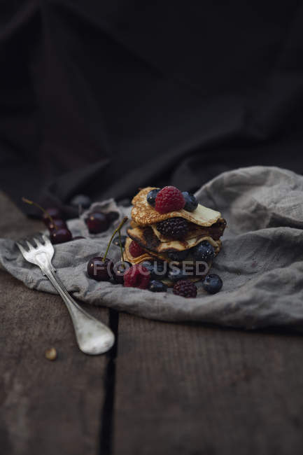 Tablecloth with pancakes and fork on table — Stock Photo