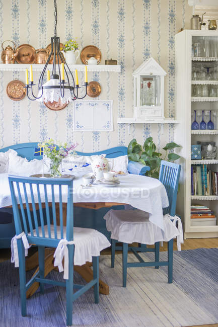 Интерьер с синей и белой мебелью и цветами на столе — стоковое фото